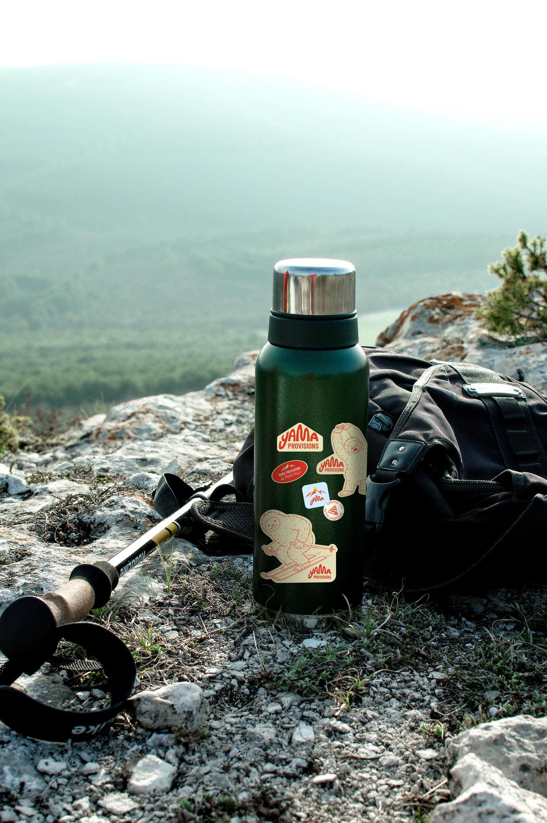 A Yama-stickered thermos resting on a summit
