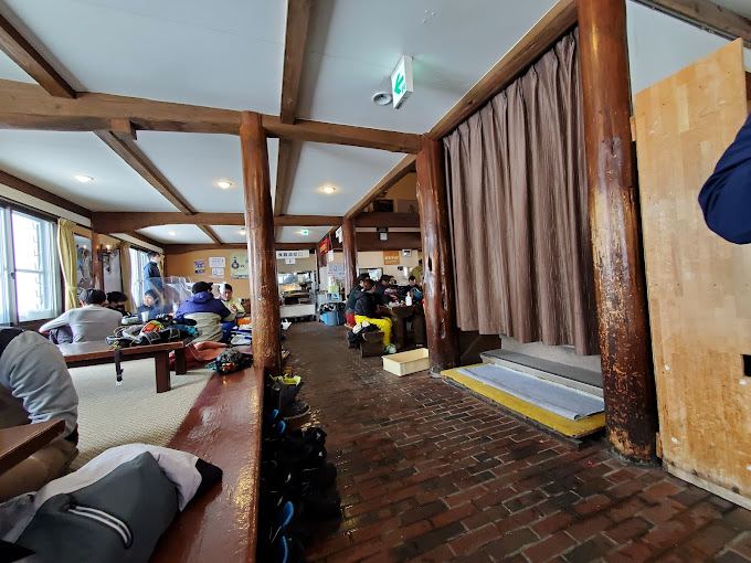 Inside the Wadagoya lodge at Kagura, a tatami room with ski boots lined up along the step